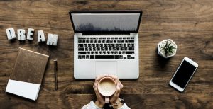 business writing online classes on laptop drinking coffee